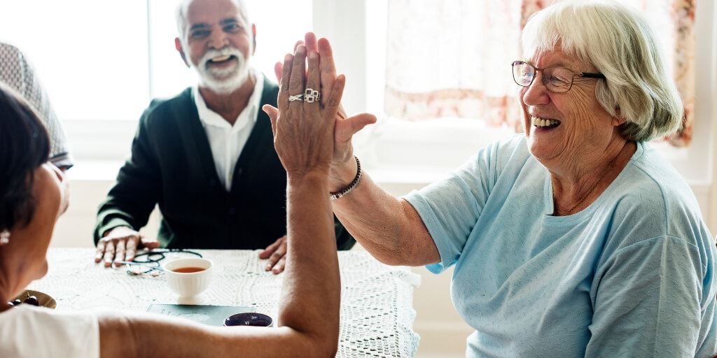 People sitting around table high-fiving.