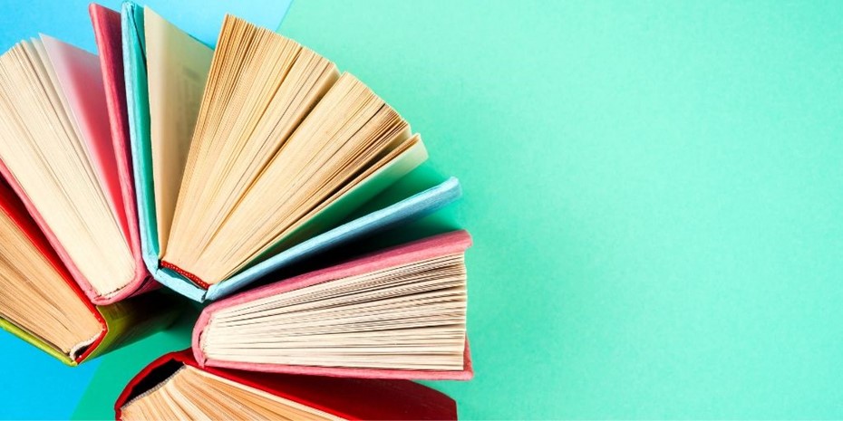 Books standing up on a light blue and green background