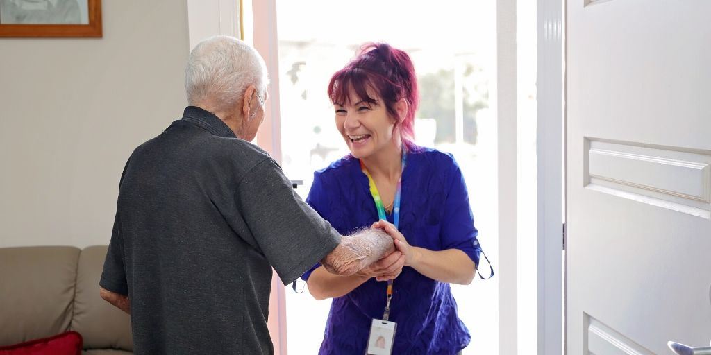 Person welcoming support worker at front door.