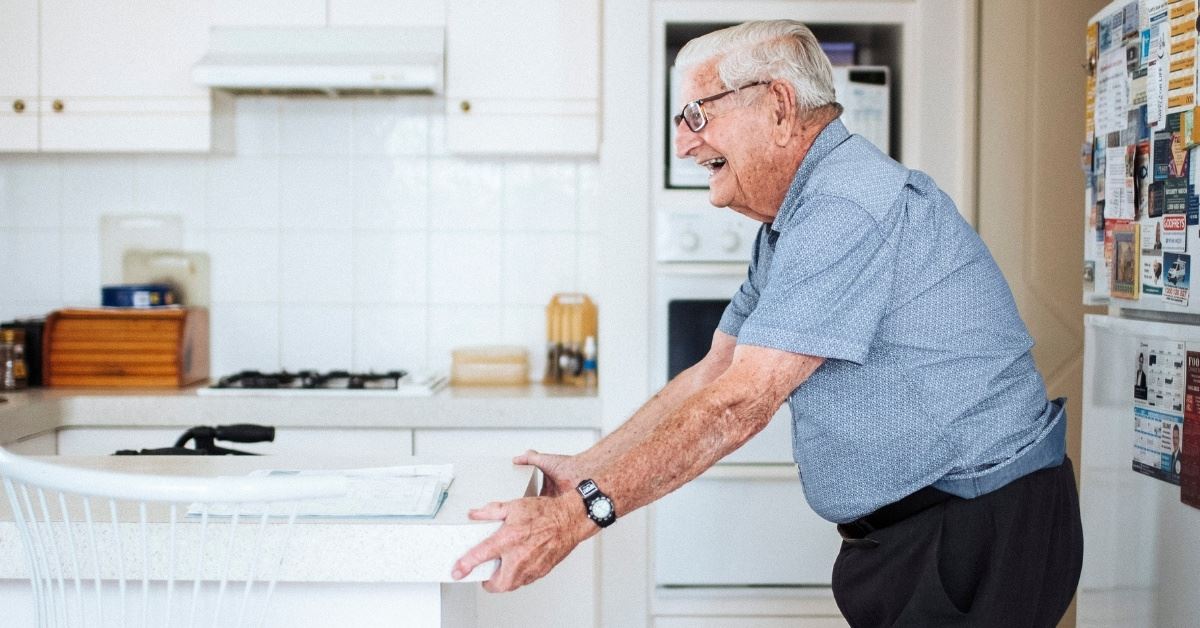 Man standing in kitchen.